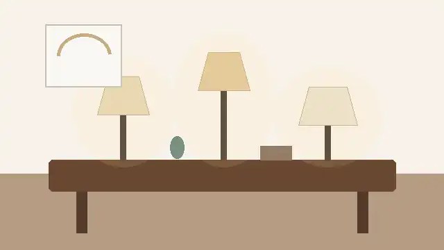 Tres lámparas de mesa de estilos distintos sobre una consola de madera en un ambiente cálido